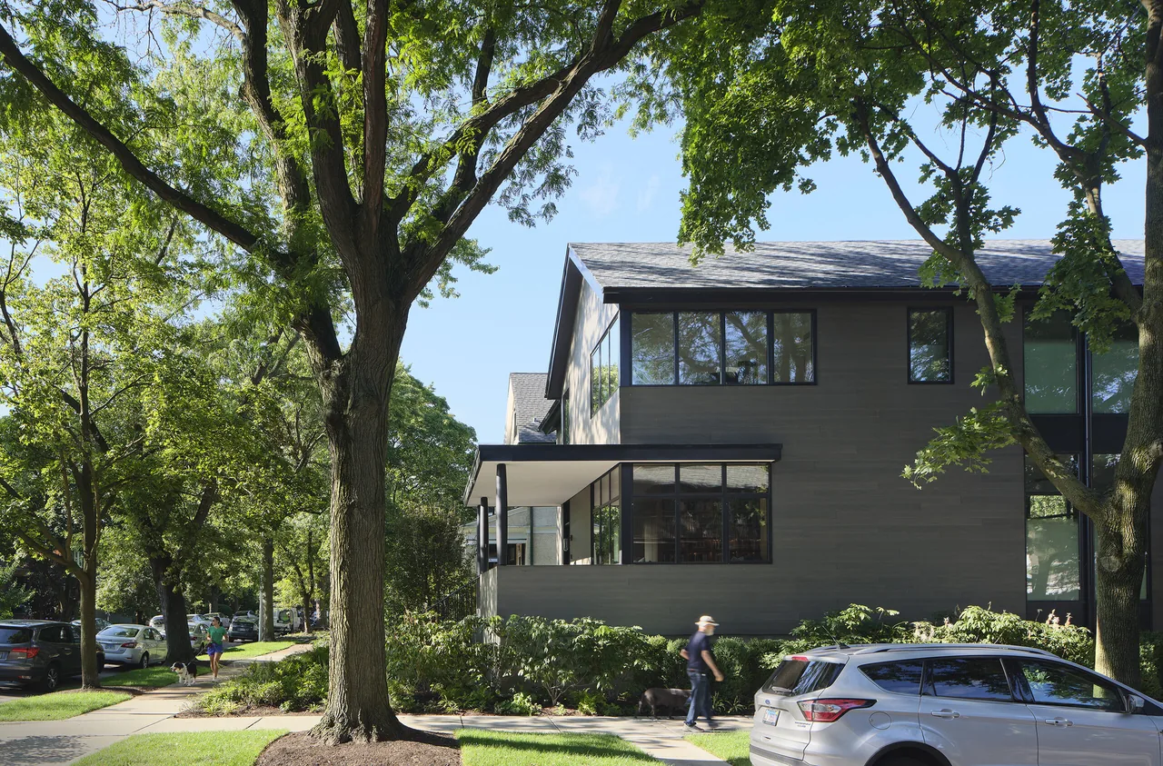 Side exterior view of the Lakewood Balmoral Residence featuring horizontal siding and large black-framed windows.