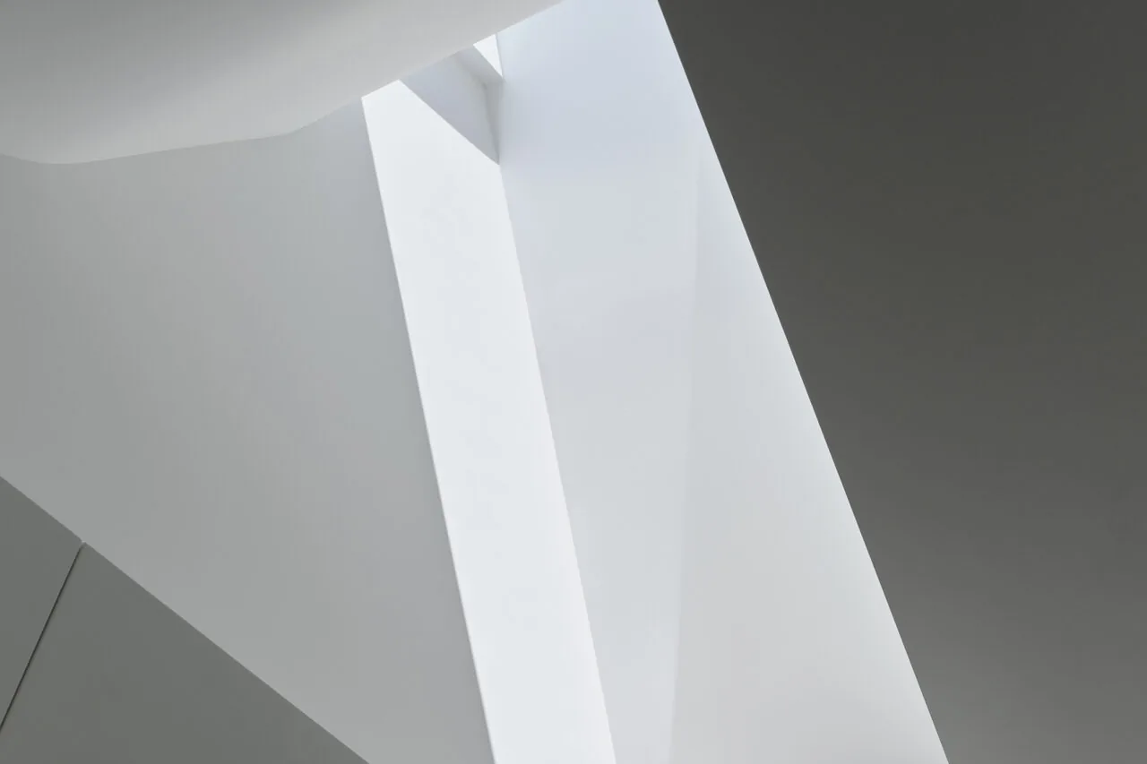 A skylight integrated into a white interior ceiling with angular geometry.