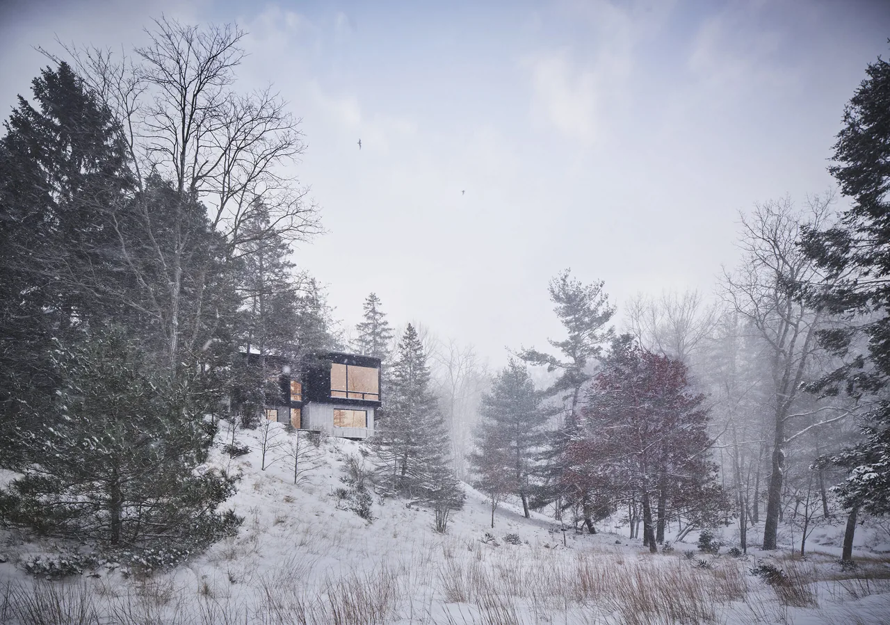 Sawyer Retreat house situated on a forested snow-covered slope in winter.