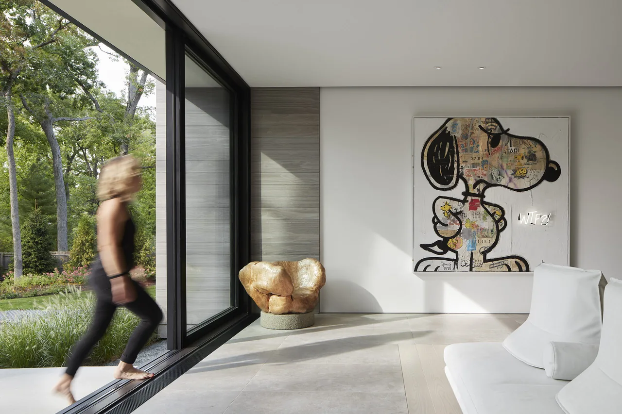 Living room with large sliding glass doors and contemporary art on the wall in the Two Gables project.