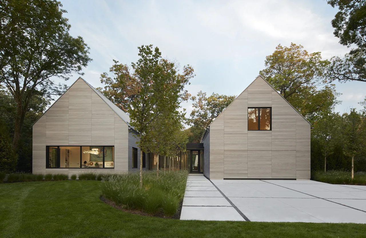 The Two Gables house by Wheeler Kearns Architects features two wood-paneled gabled volumes linked by a glass passageway.