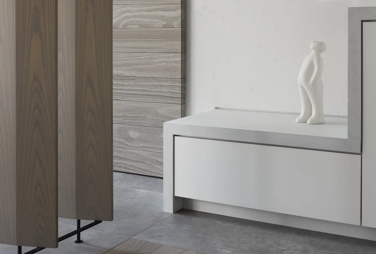 A white built-in bench next to vertical wood slats highlights texture and material contrast in the interior.