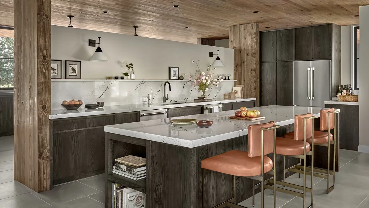 Prairie Road Retreat kitchen by Searl Lamaster Howe Architects features leather stools and dark wood cabinetry.