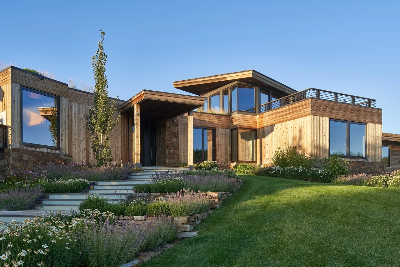 Skyline Ranch Residence features a multi-level layout with large windows, wood siding, and landscaped garden steps leading to the main entrance.