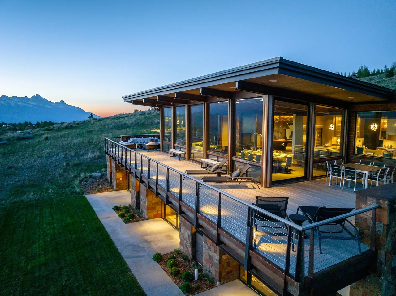 The Ridge 52 Residence features floor-to-ceiling glazing and a spacious wood deck with metal railings.