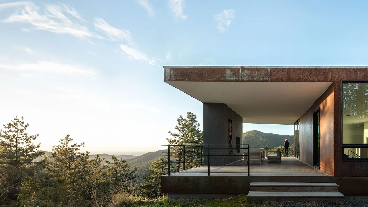 Puma Run project features a covered patio with metal railing and mountain views in a modern architectural style.