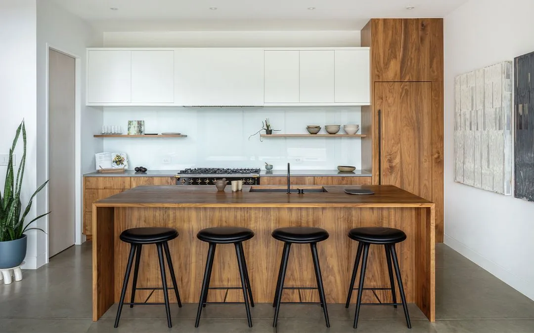 Puma Run kitchen features wood cabinetry and a large island with black stools by Arch 11 in Denver.
