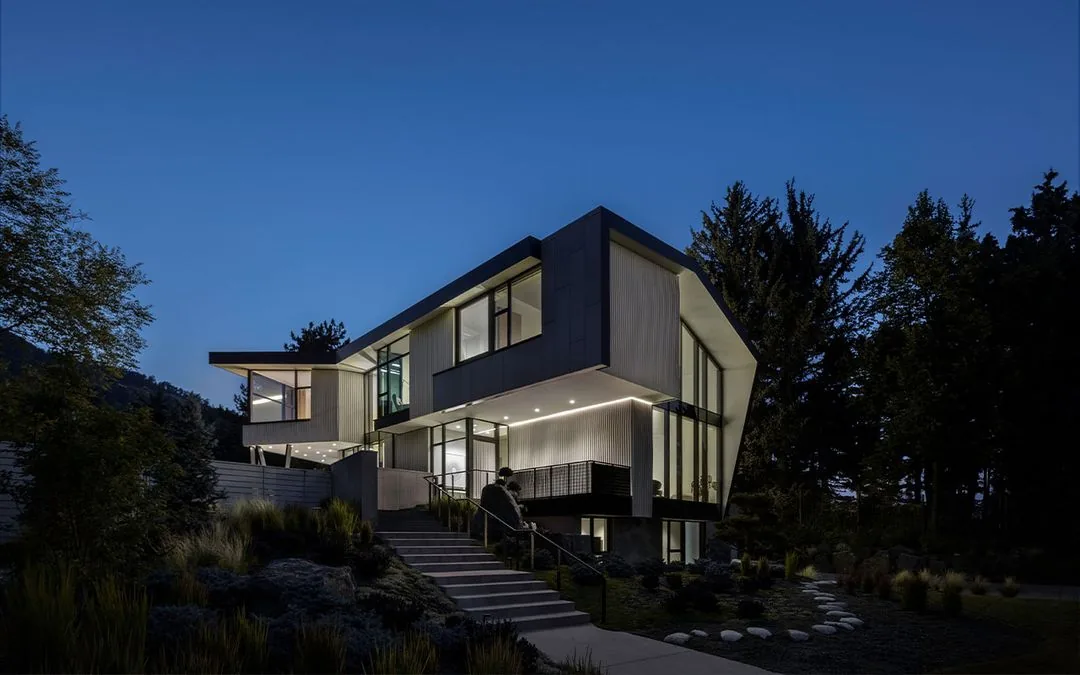 Vergence House features a modern design with large windows and exterior lighting at night.