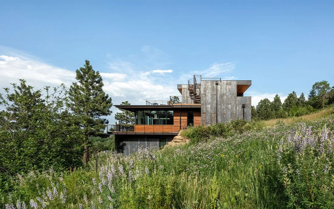 Side elevation of House 306 showing metal cladding, wood siding, and a spiral staircase accessing the rooftop deck.