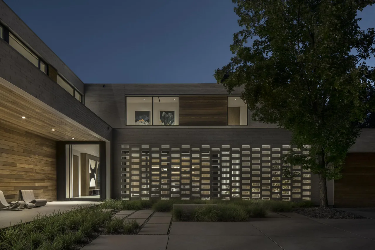 Nighttime exterior view of Parkside Villa showing perforated concrete block wall and wood siding details.
