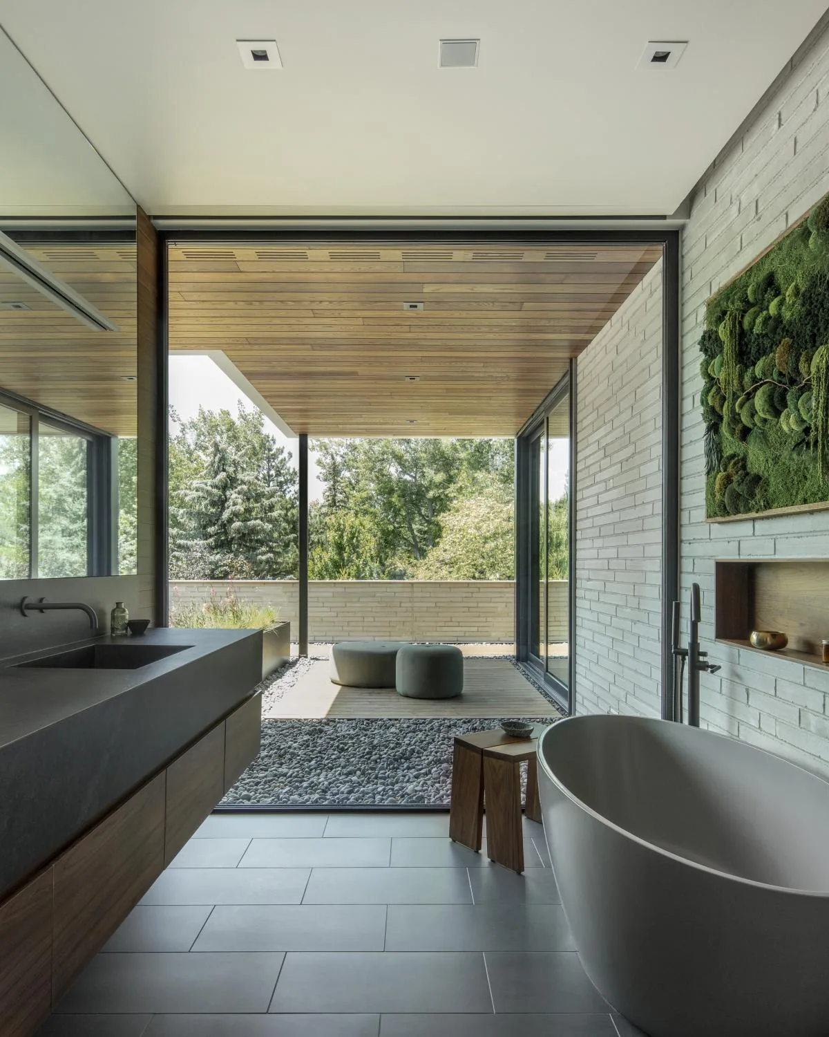 Bathroom interior featuring a freestanding tub and large glass wall opening to a covered patio.