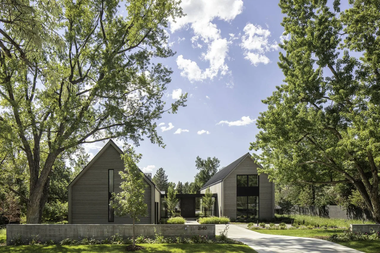 Linden Grove features two gabled structures with narrow windows, separated by a connecting element and nestled among mature trees.