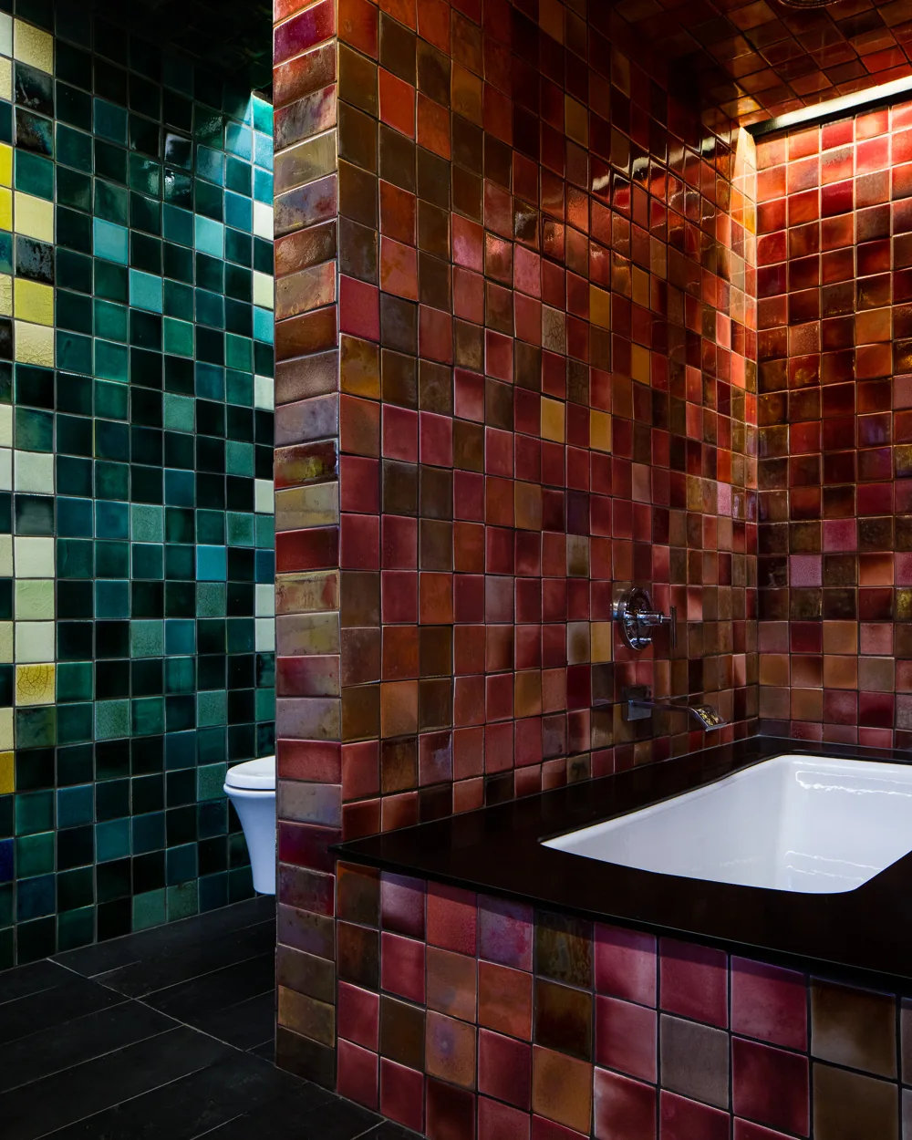 Bathroom with colorful glazed tiles covering walls around a built-in tub and adjacent toilet area.