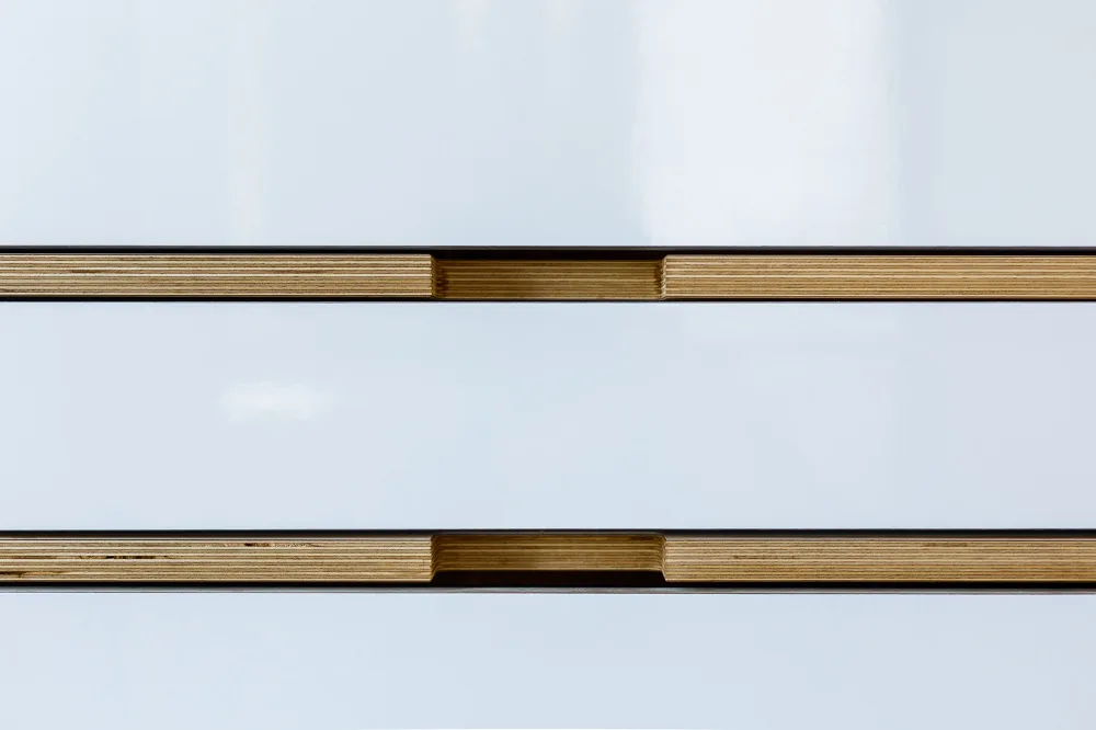 Detail of brass inlays set in a white glossy surface in the Inside Out Home project.