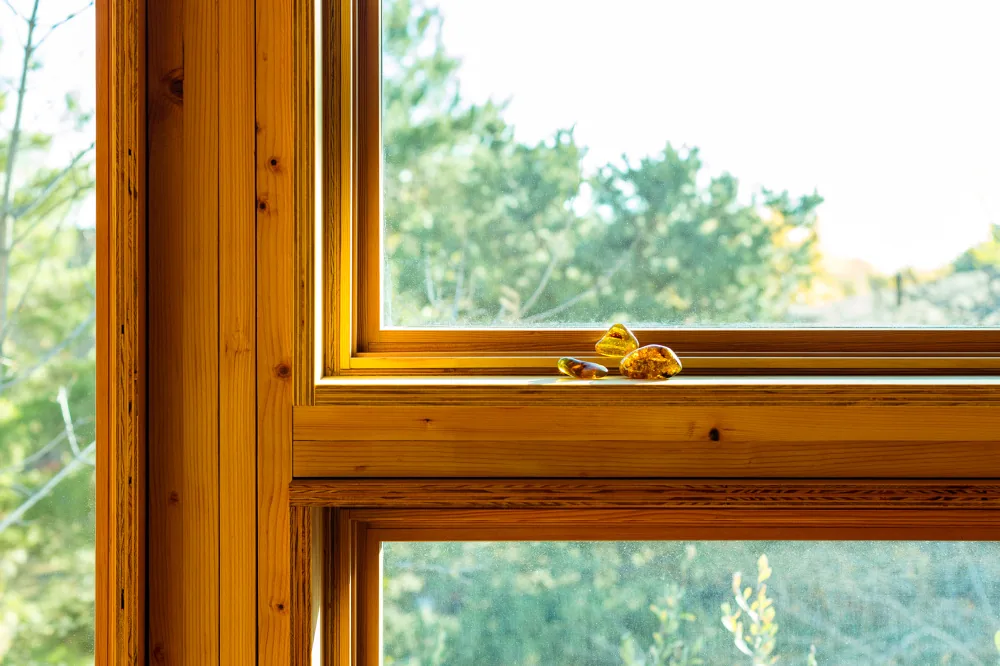 Detail of a wooden-framed window with decorative amber stones on the sill.