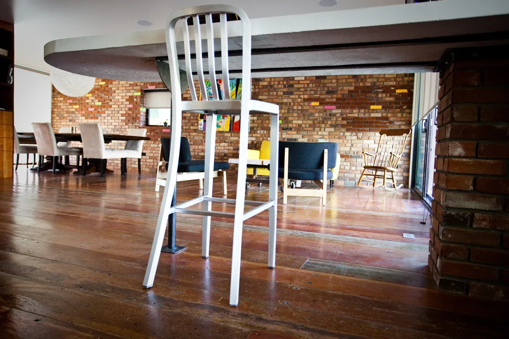Living room and dining area with wood flooring and exposed brick walls.