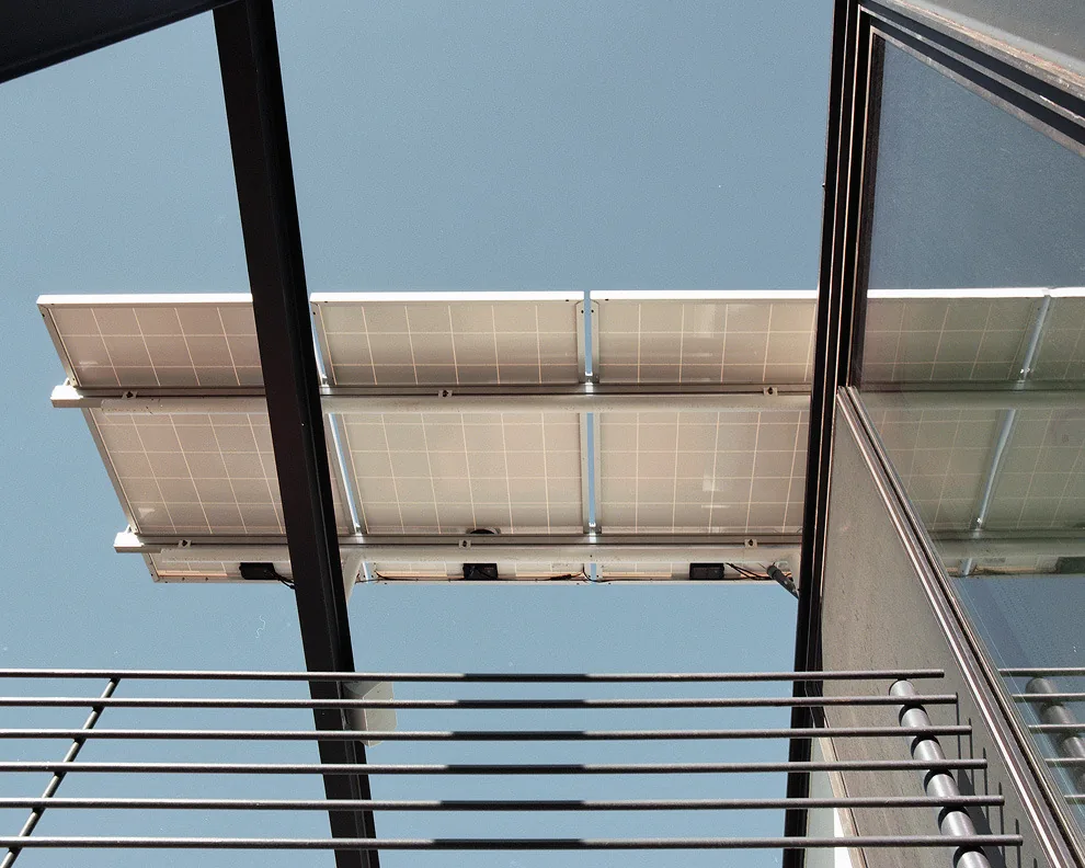 Solar panels installed on a roof structure with metal framing and railing.