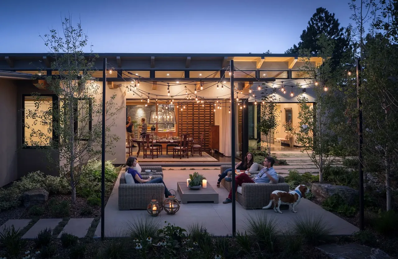 Cherry Residence outdoor patio with string lights, concrete steps, and wood ceiling beams visible inside, designed by Semple Brown Design.
