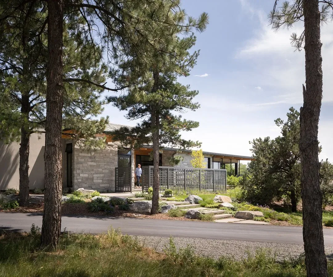 Cherry Residence features a single-story exterior with stone and stucco walls, privacy screen, and integrated landscaping.
