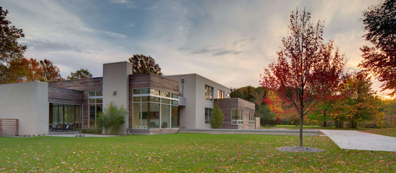 Contemporary Shaker Heights residence with mixed stucco and wood facade featuring large windows and a flat roof.