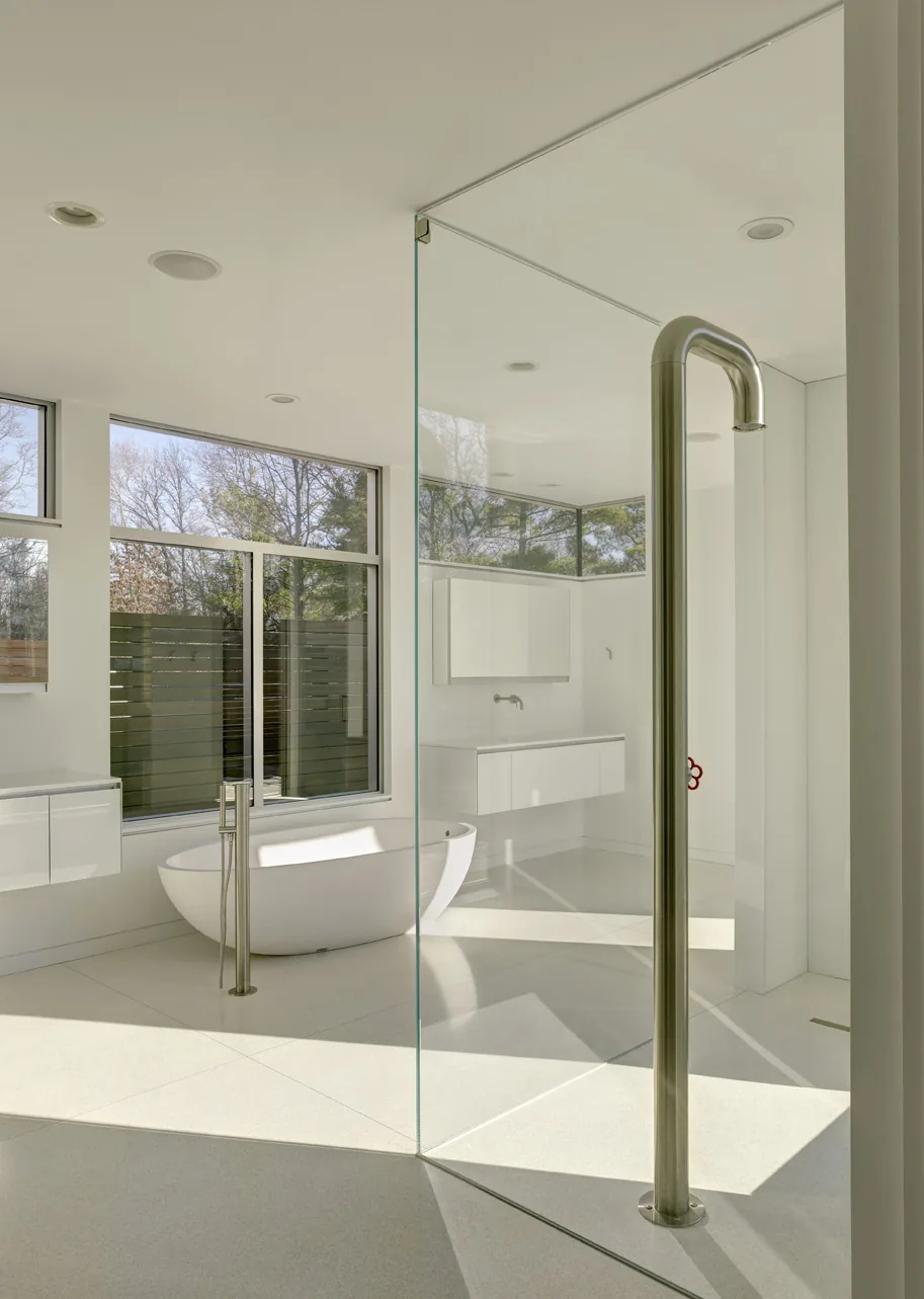 Modern bathroom featuring a freestanding tub, glass shower enclosure, and large horizontal windows.