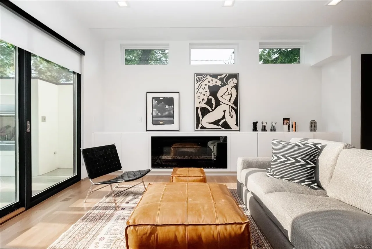 Living room with floor-to-ceiling sliding glass door, clerestory windows, built-in cabinetry, and fireplace.