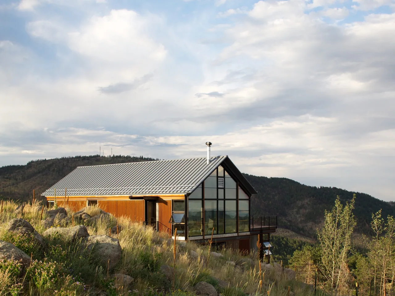Sunshine Canyon House features a metal gable roof and large floor-to-ceiling glazing on the hillside side.