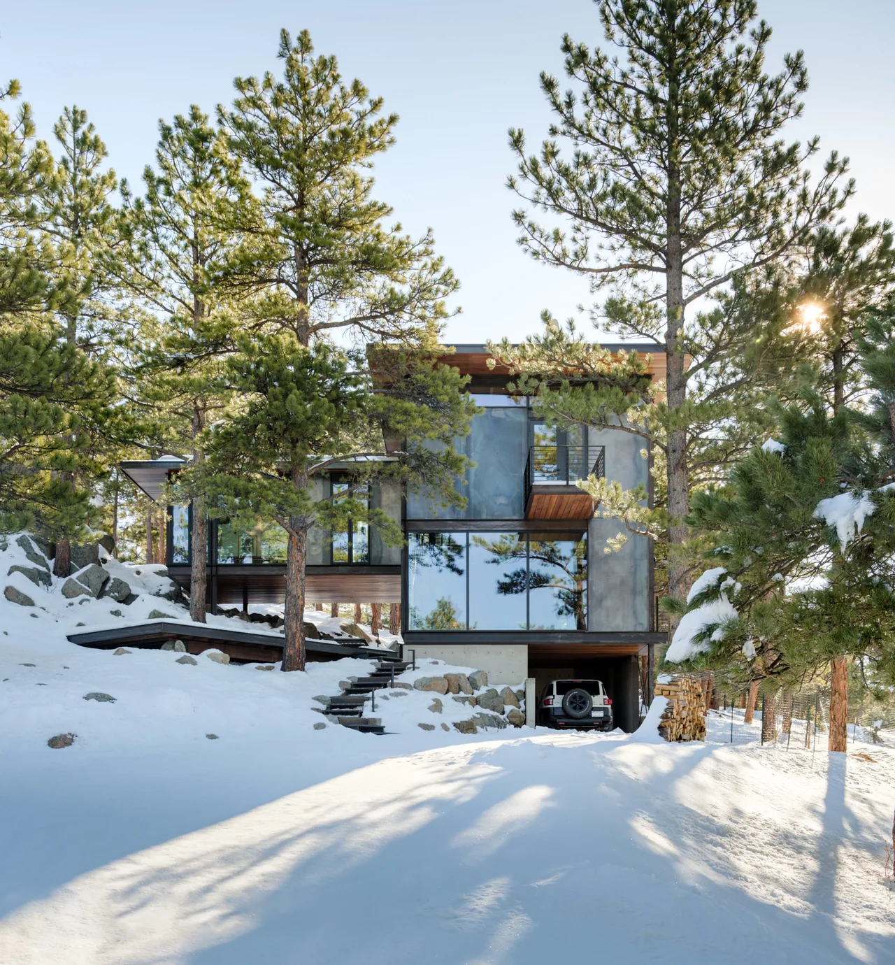 Goatbarn Lane house by Renée Del Gaudio Architecture in Denver features large black-framed windows and a snowy landscape.
