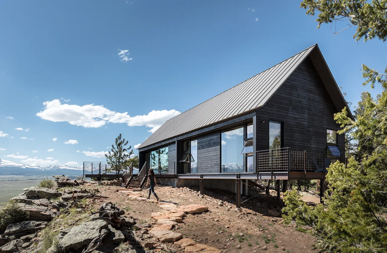 Big Cabin | Little Cabin in Denver showcases a modern raised cabin with black wood siding and a metal gable roof.