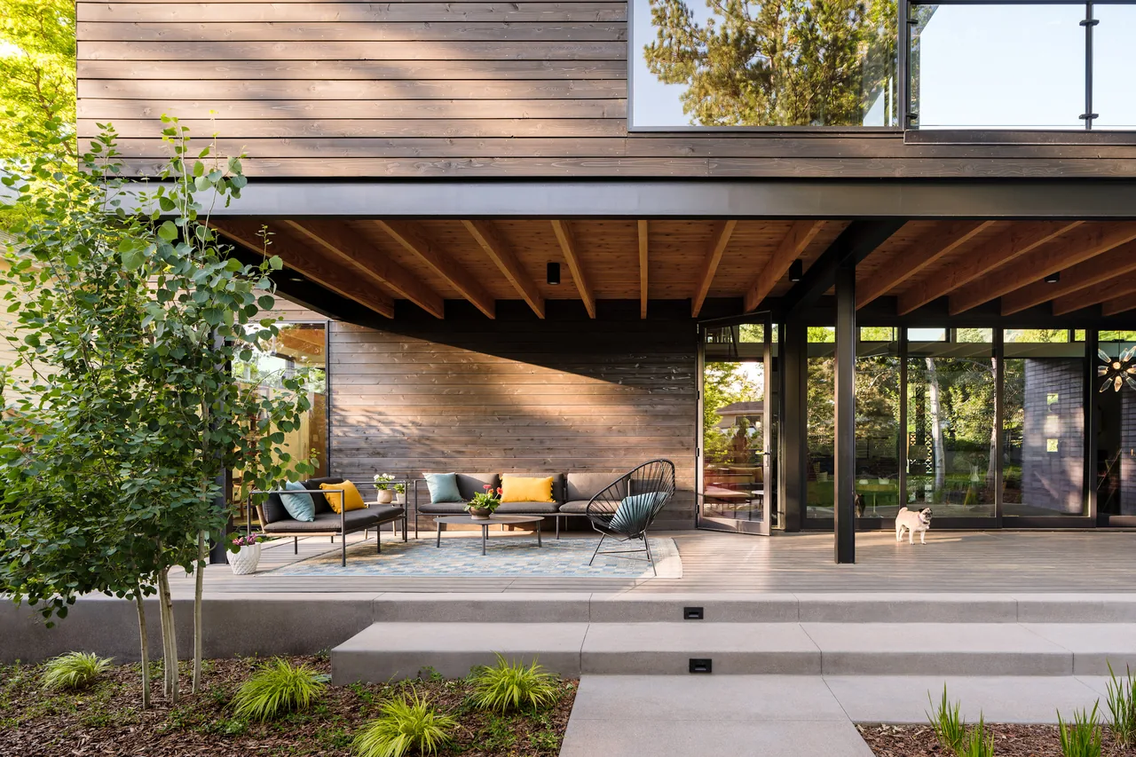 Mariposa Garden House features a covered patio with wood siding and large glass doors opening to the garden.
