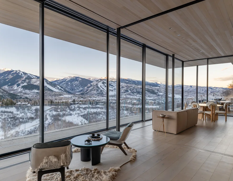 The Sunshine Mountain home features floor-to-ceiling glazing to capture expansive mountain and snowy landscape views.