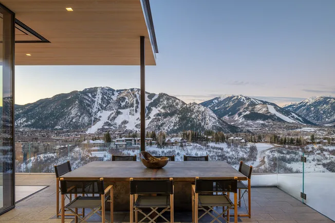 Covered patio dining area with a mountain view at Sunshine Mountain project in Denver.
