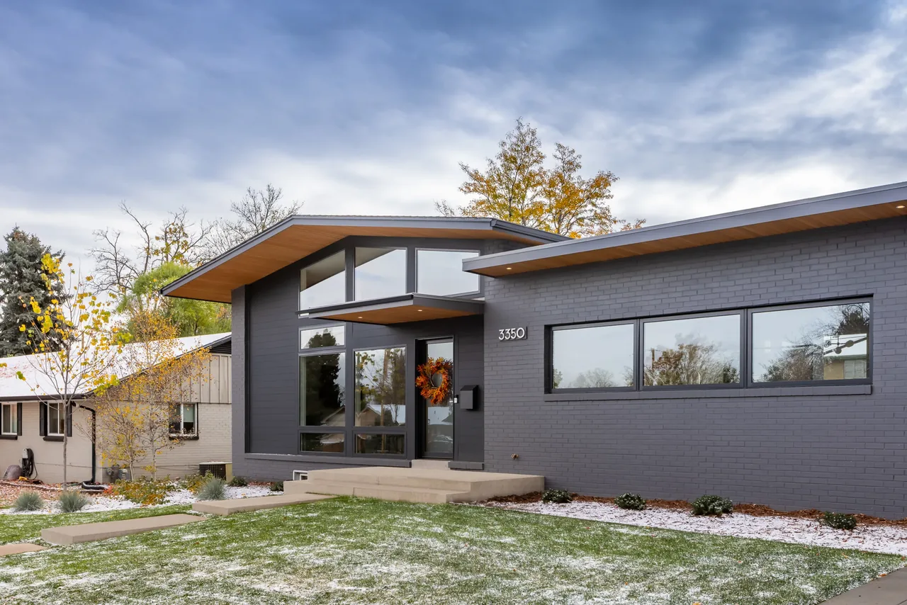 Exterior front of Centennial Modern Ranch featuring dark gray brick and floor-to-ceiling glazing by Cadence Studio in Denver.