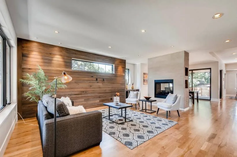 Living room features a wood plank accent wall with a narrow horizontal window and a central fireplace.