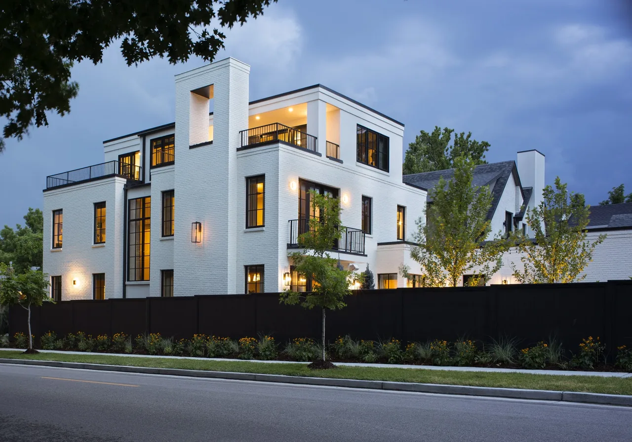 Denver Residence 12 features white painted brick exterior and black metal railings on balconies and terraces.