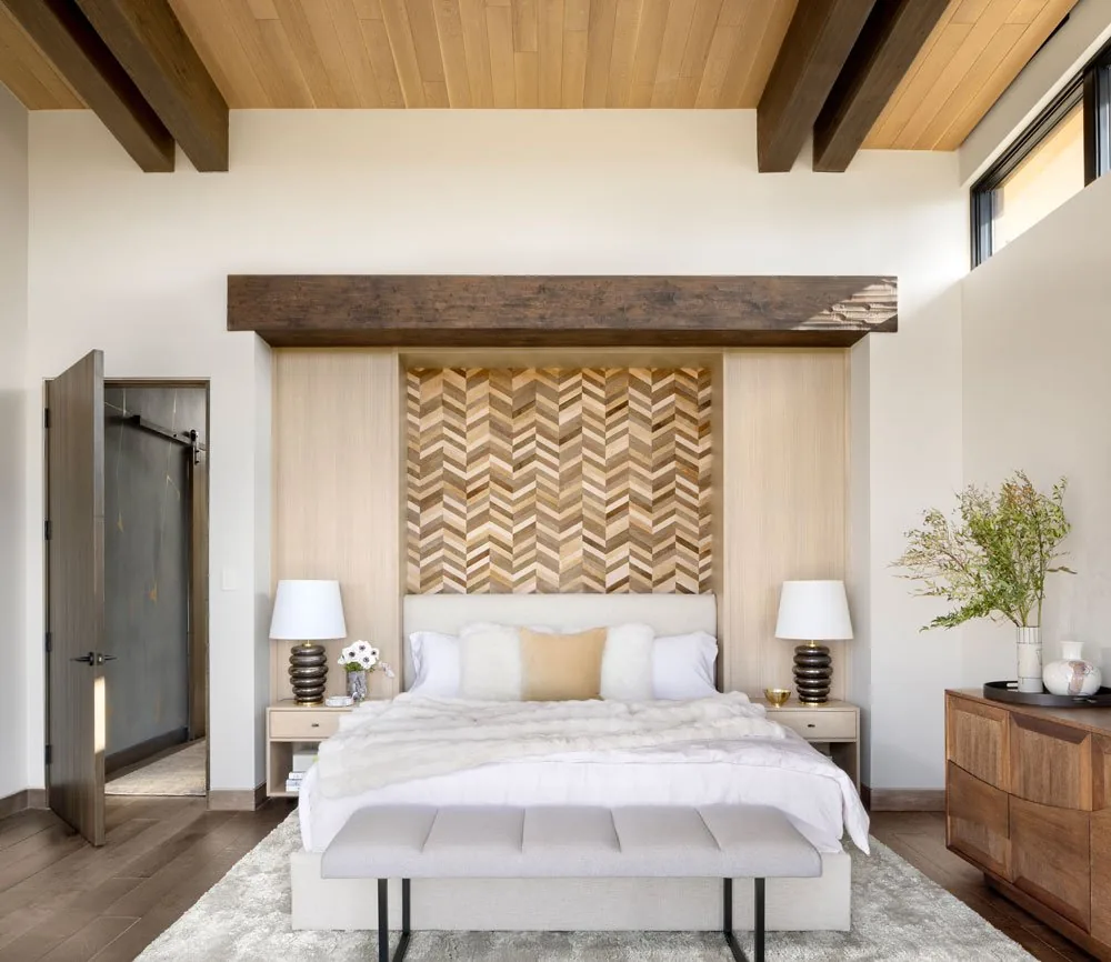 Bedroom featuring wood accent wall paneling, ceiling beams, and clerestory windows illuminating the space.