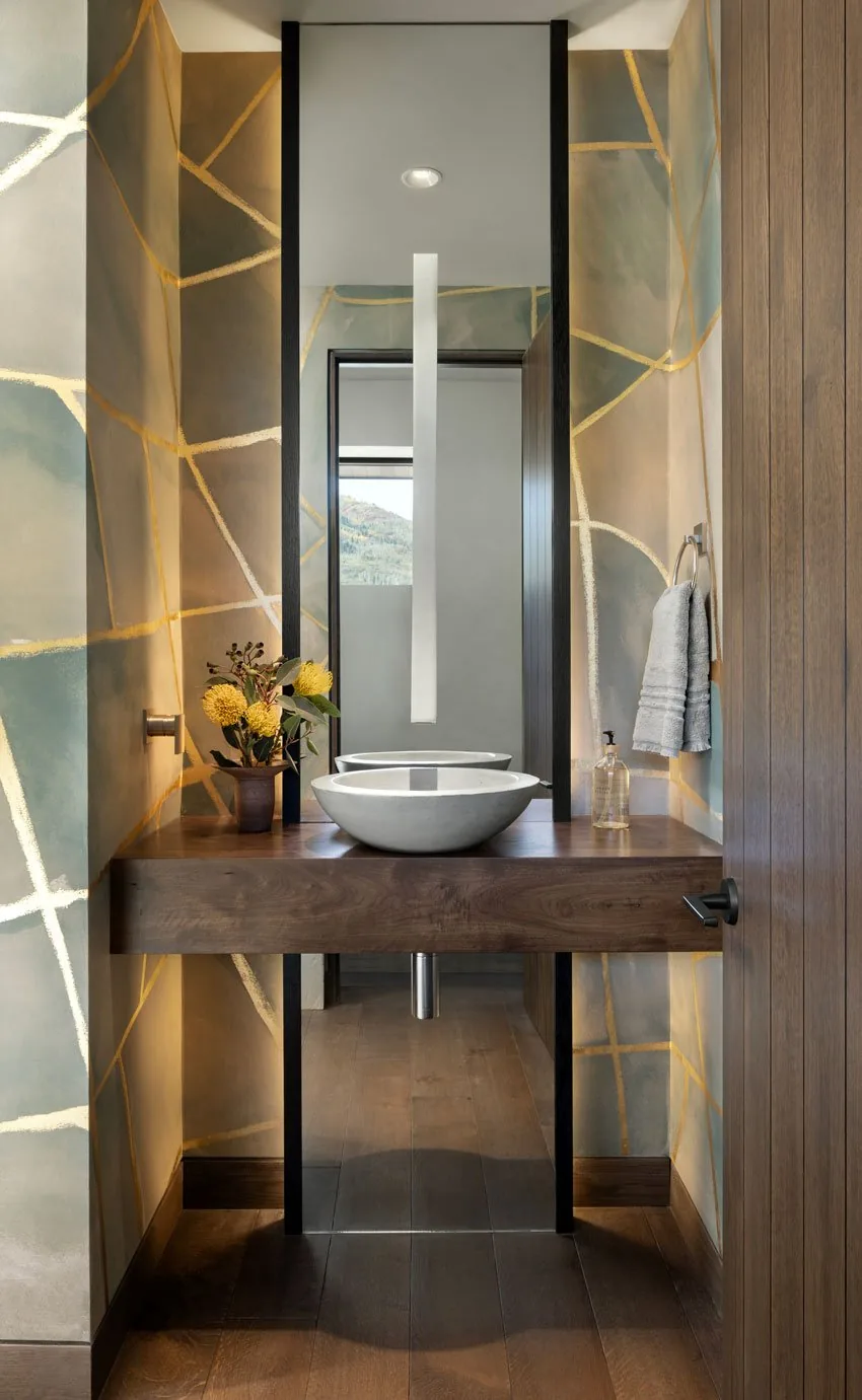 Powder room featuring a wooden floating vanity with a concrete vessel sink and abstract geometric wall patterns.