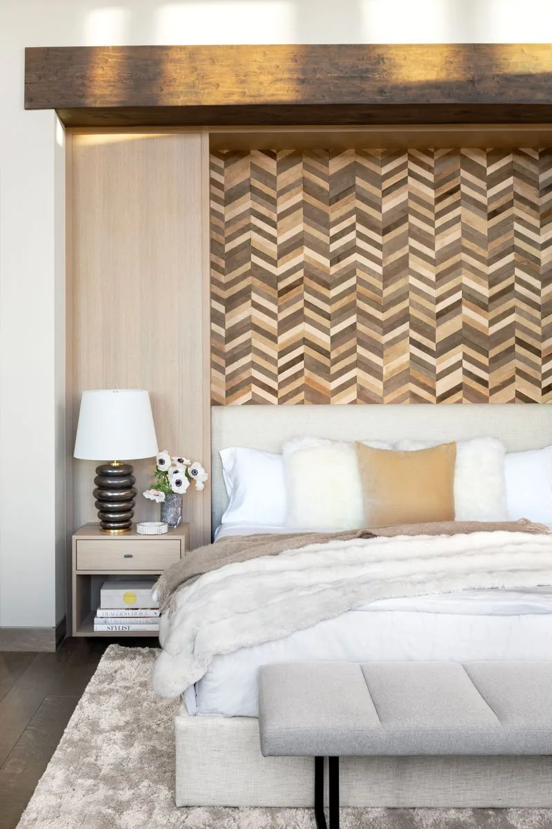 Wood accent wall and bedroom furnishings including nightstand and upholstered bench.