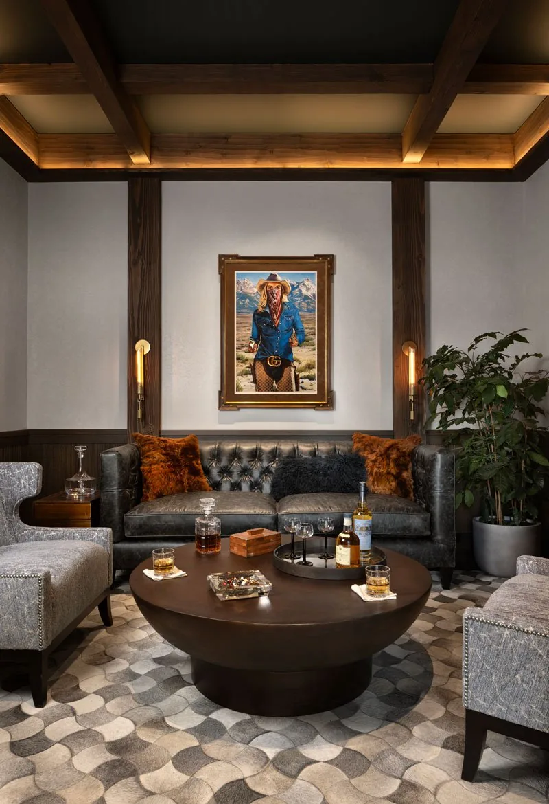 Living room interior showing leather tufted sofa, wood beam ceiling, and round coffee table with drinks.