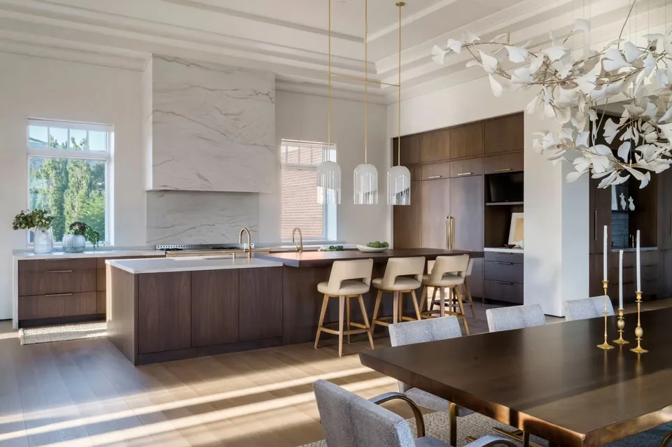 Kitchen and dining area featuring dark wood cabinetry, a marble backsplash, and pendant lighting.