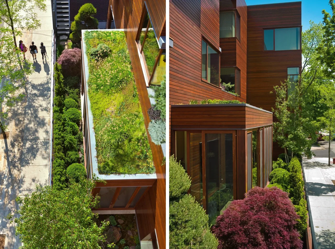 View of a three-story residence clad in horizontal wood siding with a green roof and landscaped setback adjacent to the sidewalk.
