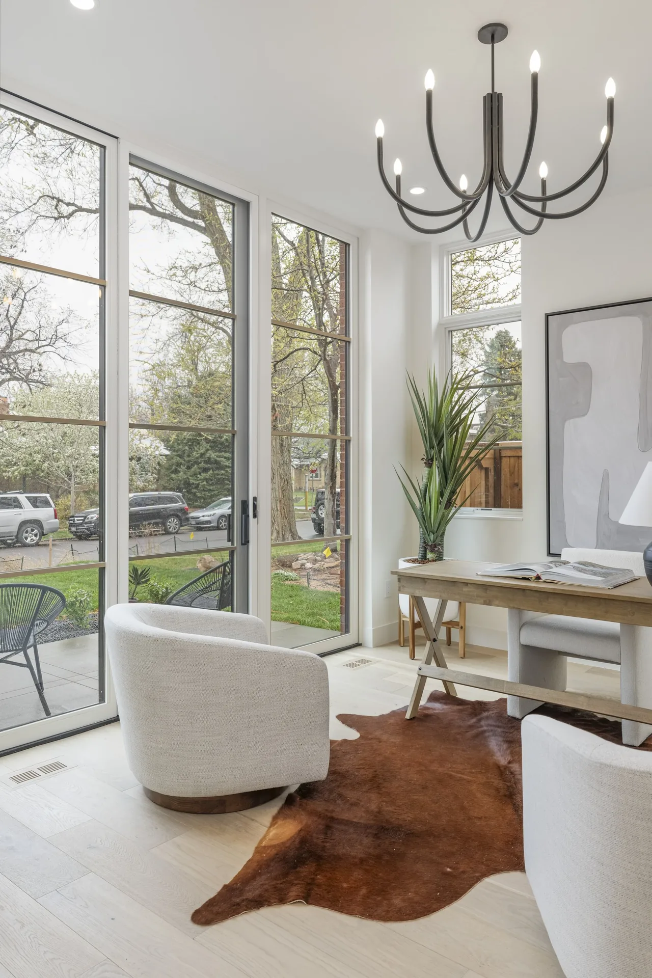 Modern office space features floor-to-ceiling sliding glass doors and light wood flooring.