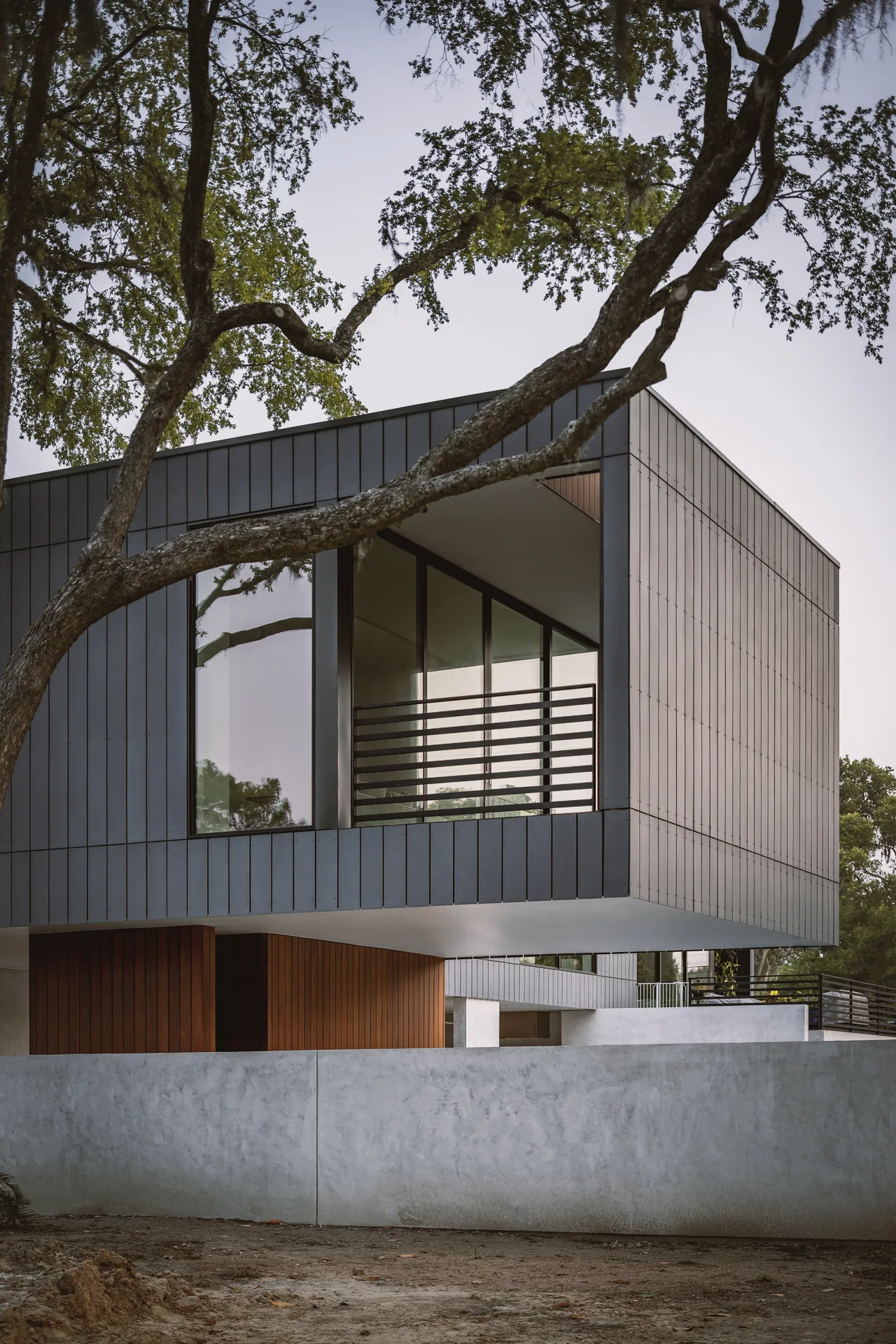 The Grennoch Residence features a cantilevered second story with vertical dark siding and corner windows.