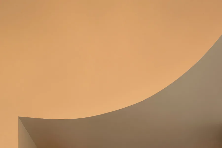Curved ceiling with smooth transition between beige and gray tones.