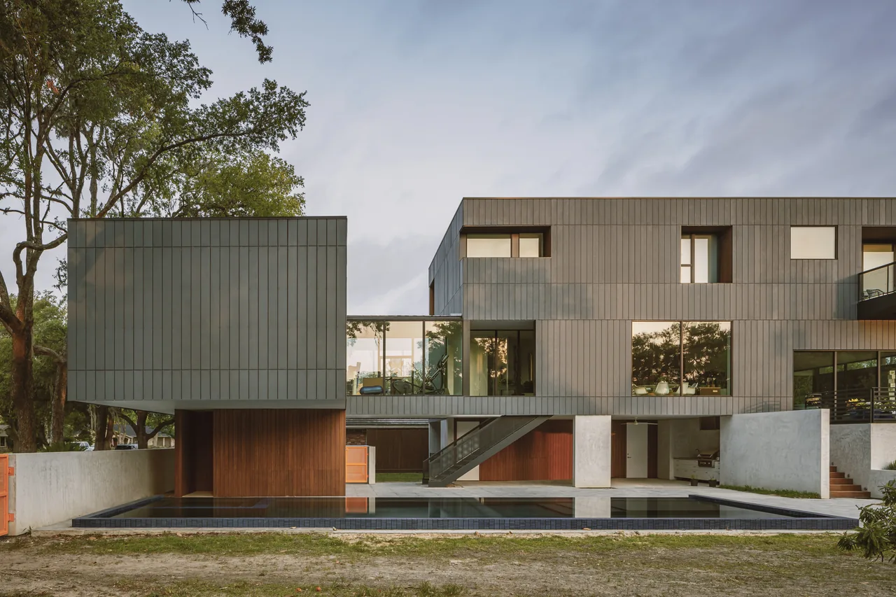 Grennoch Residence features a modern exterior with vertical wood paneling and a reflecting pool, designed by CONTENT Architecture in Houston.