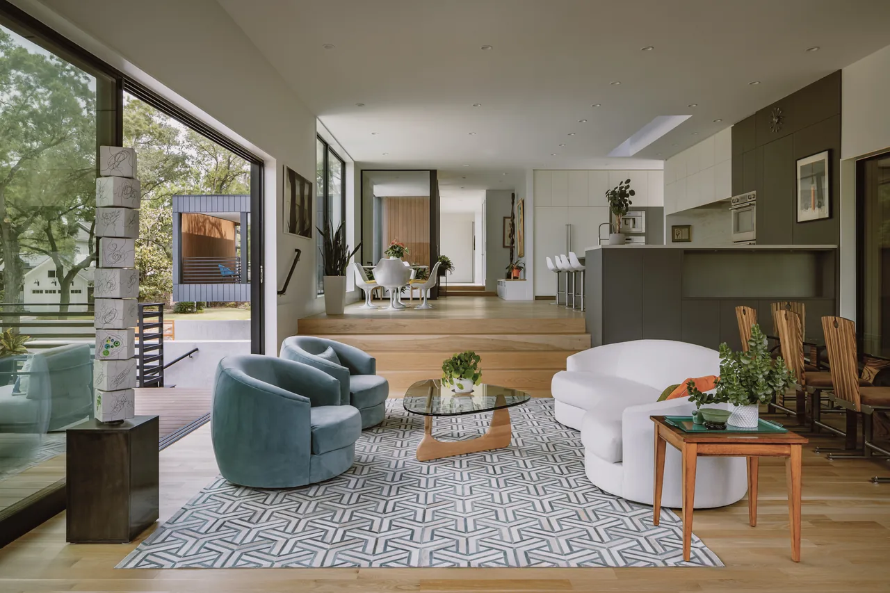 Living room and kitchen area of the Grennoch Residence with large windows and a geometric rug