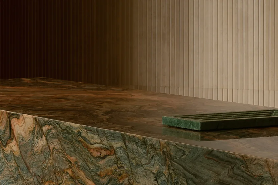 Kitchen island with prominent veined stone and a ribbed textured wall at Grennoch Residence.