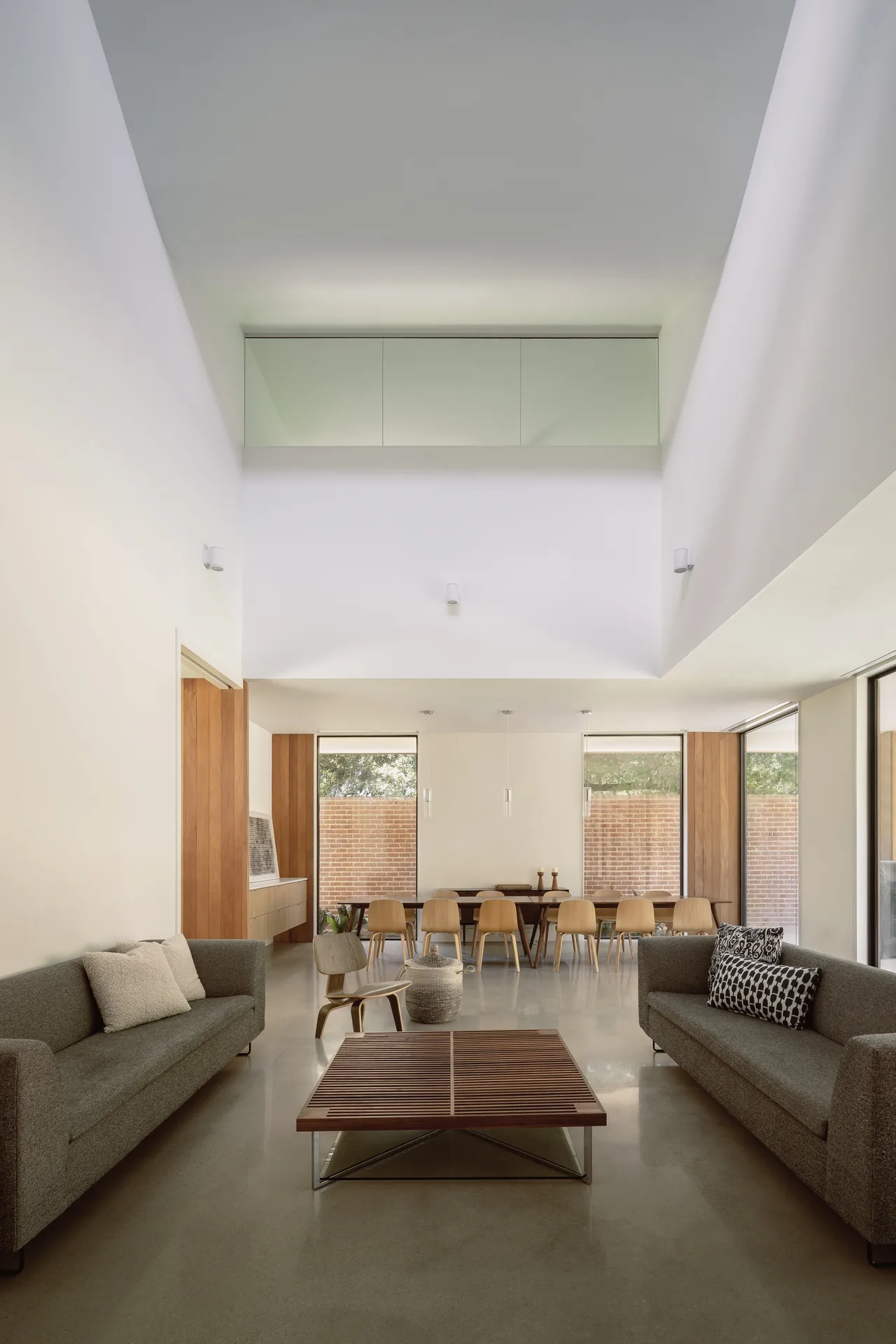 The Rice Magister House features an open living and dining space with natural light and wood-paneled columns.