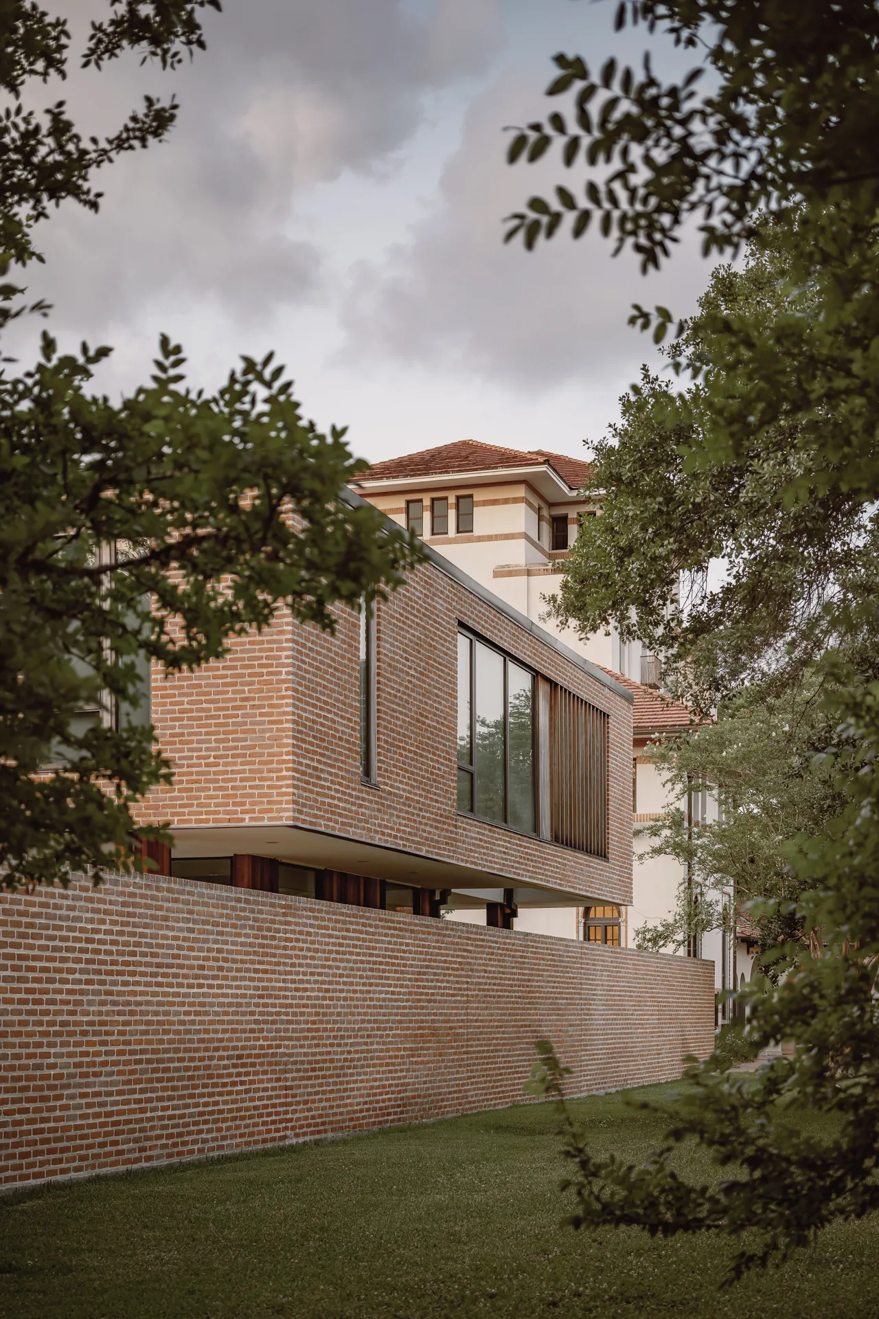 Brick exterior of the Rice Magister House extension with vertical wooden slats and large windows.