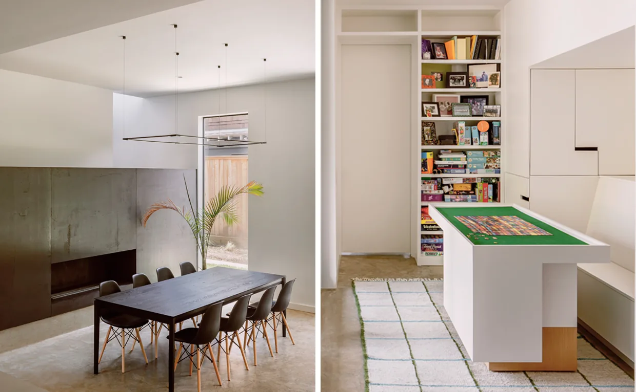 A dining area features a concrete floor, contemporary fireplace, minimalist lighting, and tall window, adjacent to a game room with built-in shelving and custom game table.